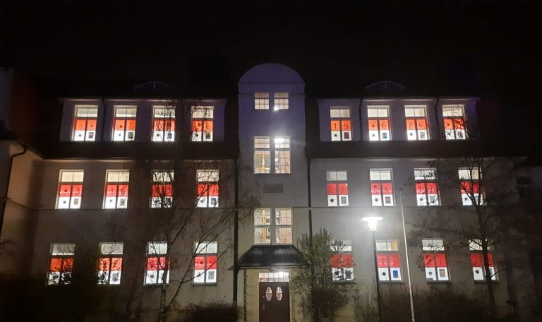 Fensterkalender der Schule leuchtet in der Vorweihnachtszeit